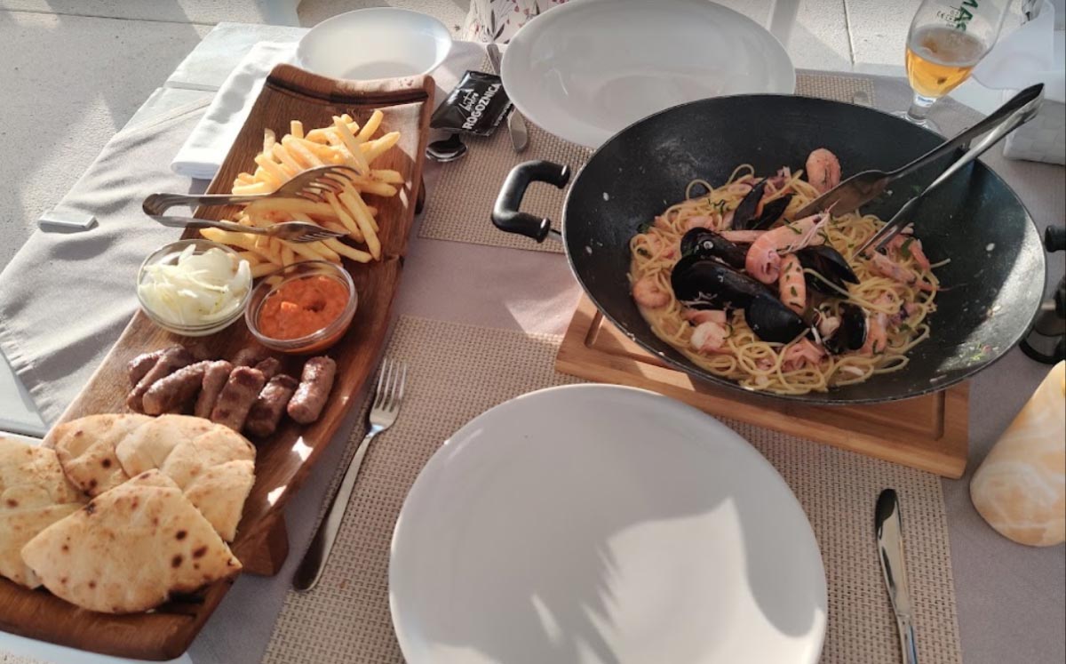 plate flatbread čevapi pommes shrimp pasta mussels on the table